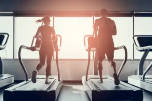 Man and woman running on treadmill
