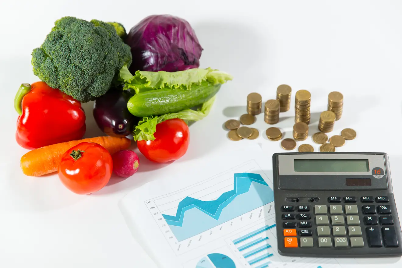 Vegetables, money, and calculator on table