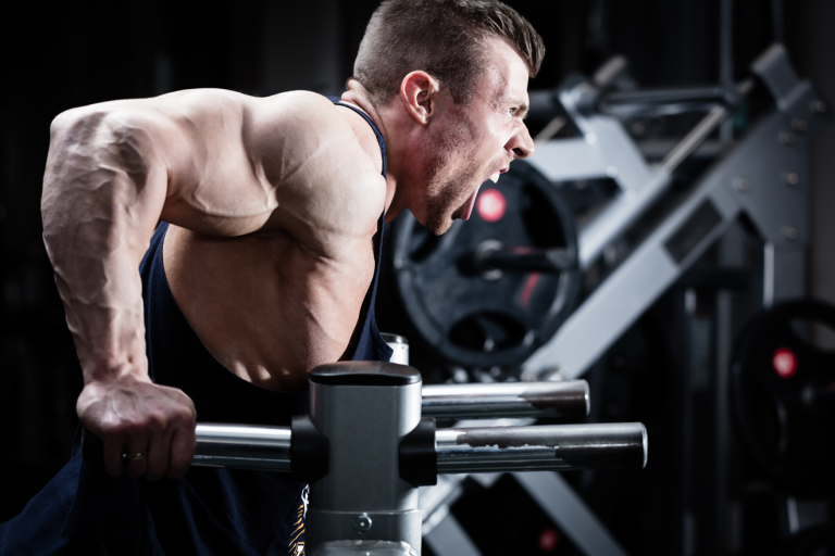 Man in gym doing triceps dip