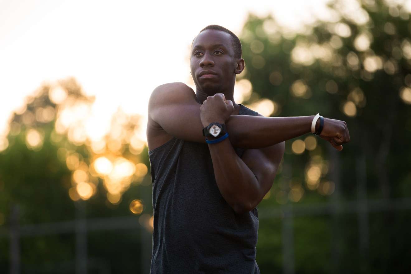 black man stretching his shoulders outside