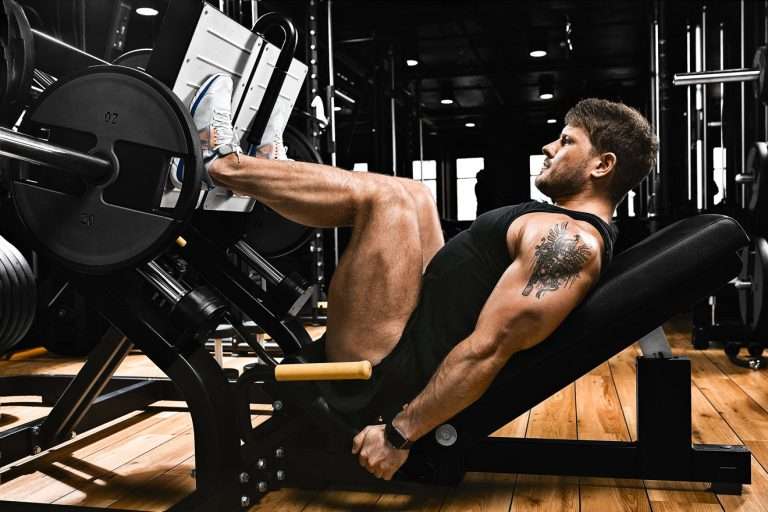 Man in gym doing heavy sled leg press
